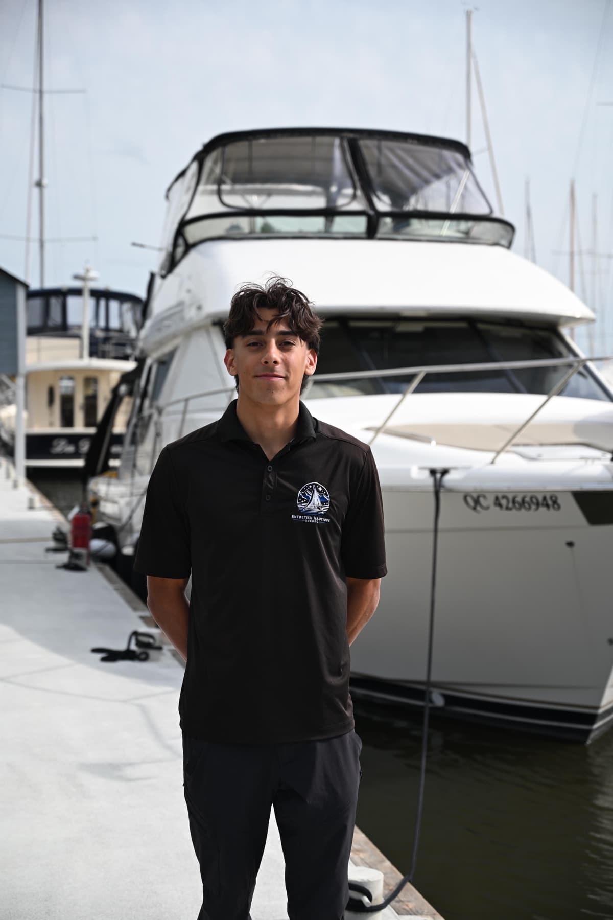 Liam d’Entretien Nautique Québec devant un bateau