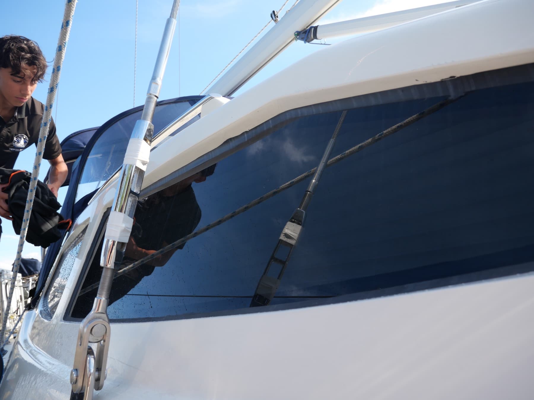 Technicien nettoyant les surfaces extérieures d’un bateau à la marina
